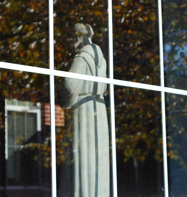 This is the same statue of St. Francis taken from outside. It sits on the ledge of a gymnasium window.