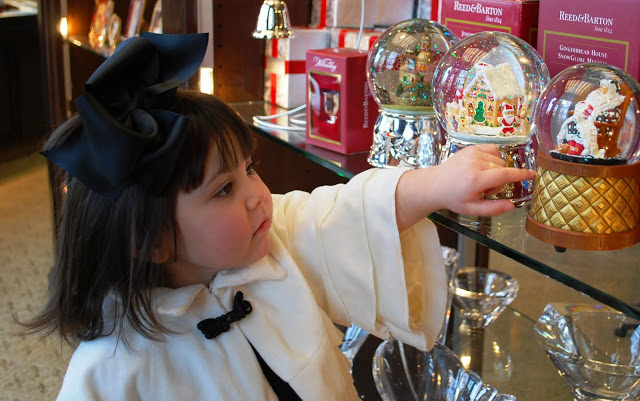 Little girl looking at snow globes