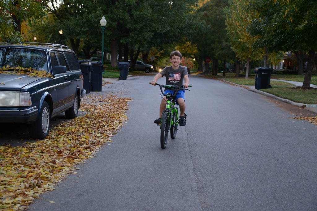Boy Riding Bike Down Middle of Street